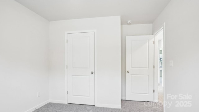 unfurnished bedroom with carpet and baseboards