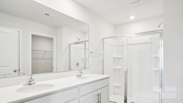 full bathroom with visible vents, a sink, and a shower stall