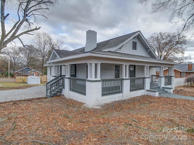 view of home's exterior featuring a porch and a shed