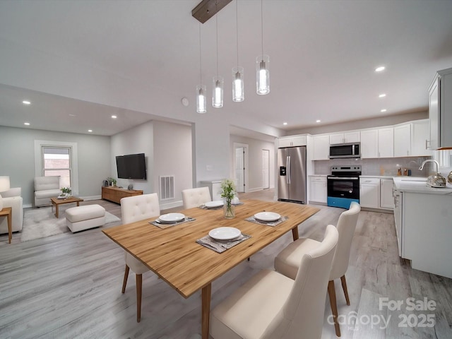 dining room with light hardwood / wood-style floors and sink