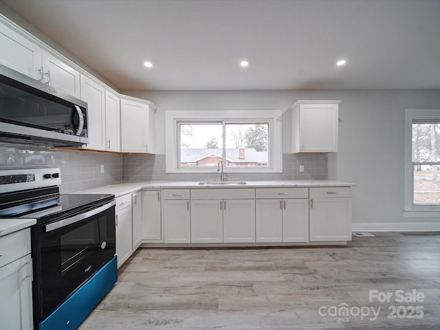 kitchen with sink, white cabinetry, and appliances with stainless steel finishes