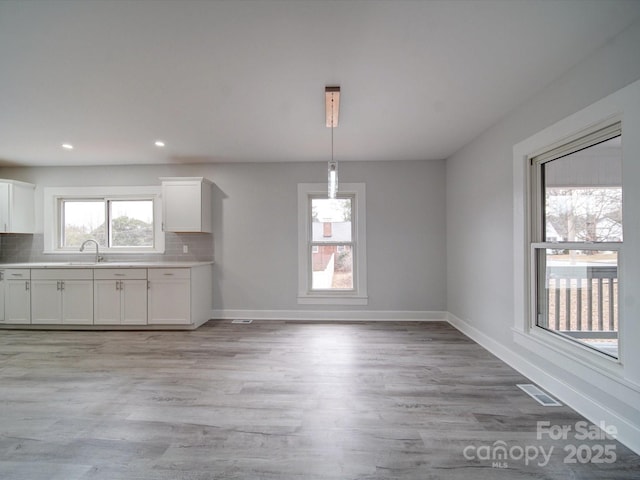 unfurnished dining area with light wood-type flooring and sink