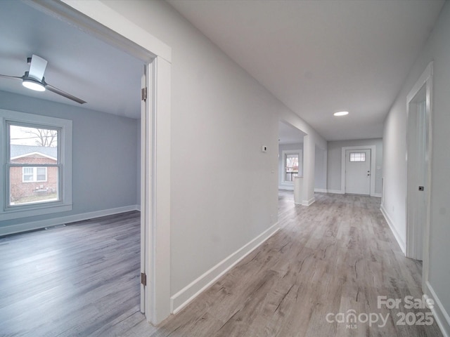 hallway featuring a wealth of natural light and light hardwood / wood-style flooring