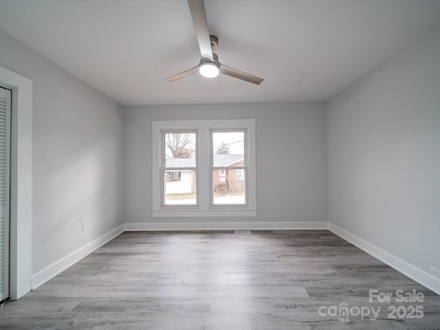 empty room with ceiling fan and light hardwood / wood-style flooring