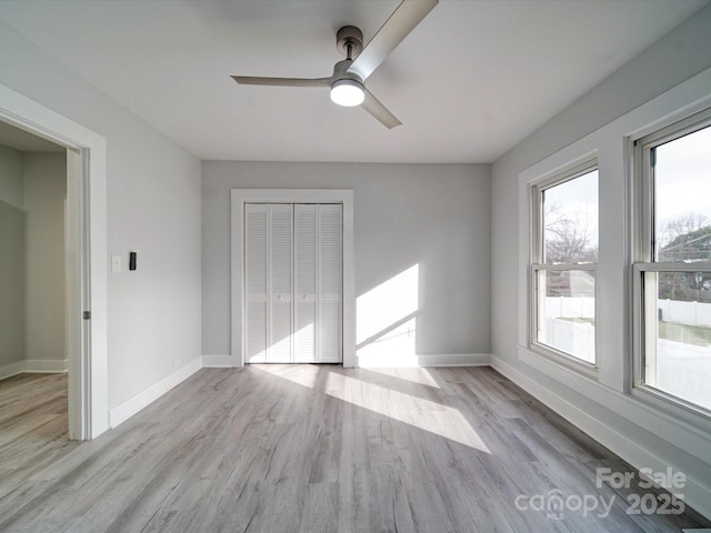 unfurnished bedroom with ceiling fan, a closet, and light hardwood / wood-style flooring