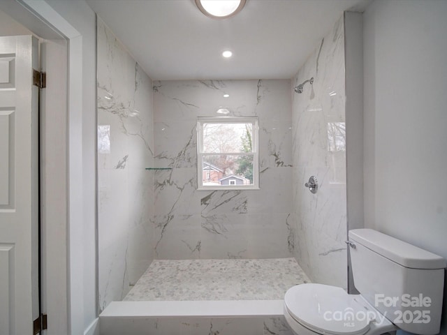 bathroom featuring toilet and tiled shower