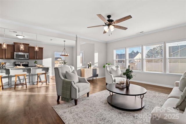 living room featuring dark hardwood / wood-style flooring, ceiling fan, and ornamental molding