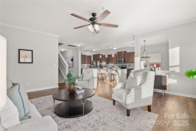 living room featuring dark hardwood / wood-style flooring, ceiling fan, and ornamental molding