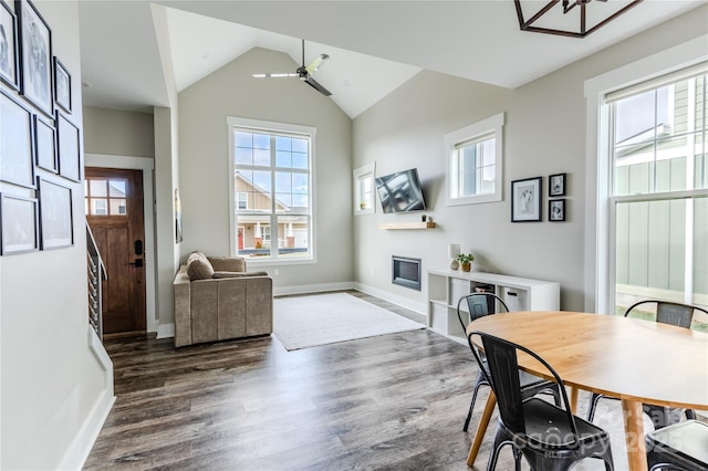 dining space with ceiling fan, dark wood-type flooring, and vaulted ceiling