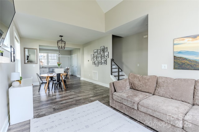 living room with vaulted ceiling, a chandelier, and hardwood / wood-style floors