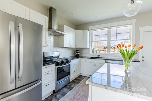 kitchen with white cabinets, sink, appliances with stainless steel finishes, and wall chimney range hood