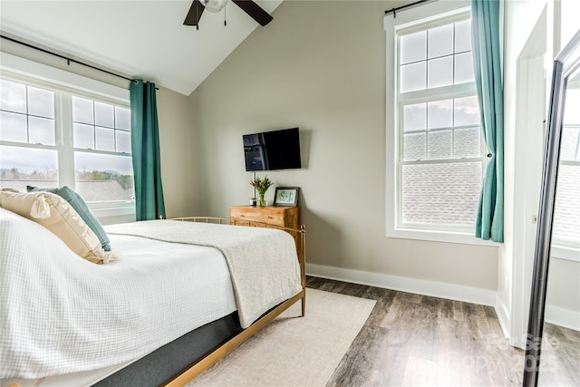 bedroom featuring ceiling fan, multiple windows, high vaulted ceiling, and hardwood / wood-style floors