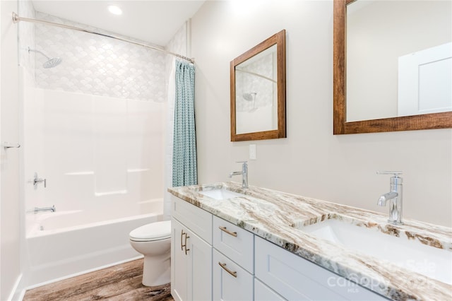 full bathroom featuring shower / bath combo with shower curtain, wood-type flooring, toilet, and vanity