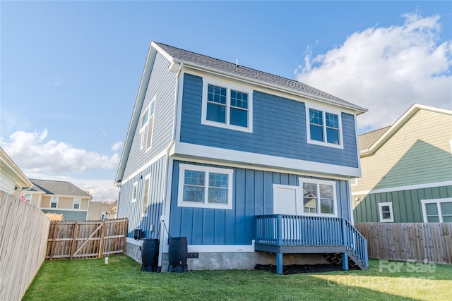 back of property featuring a lawn and a wooden deck