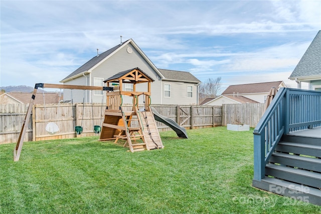 view of playground with a lawn and a deck