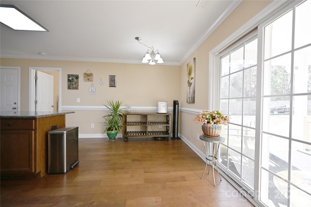 dining room with an inviting chandelier, a skylight, crown molding, and light hardwood / wood-style floors