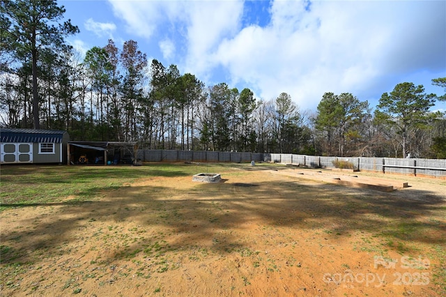 view of yard featuring a shed and a fire pit