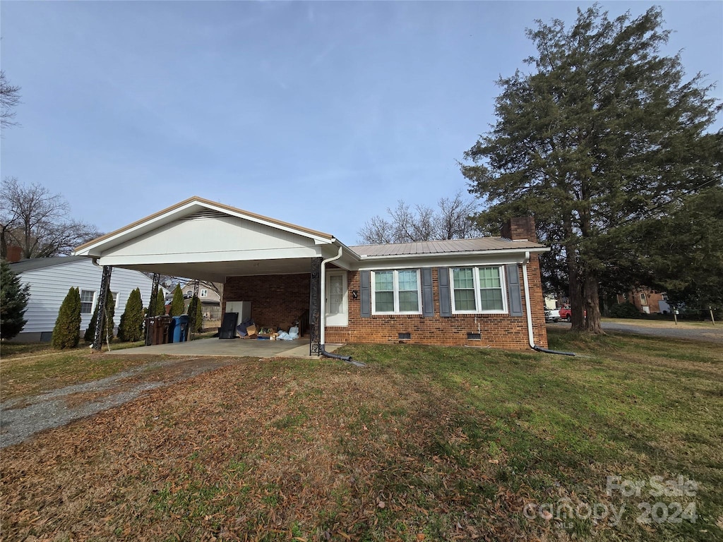 single story home with a front lawn and a carport