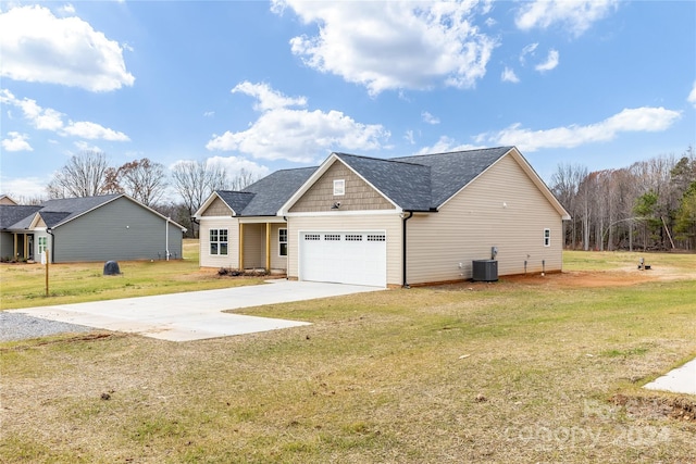 view of front of property with central AC, a front lawn, and a garage