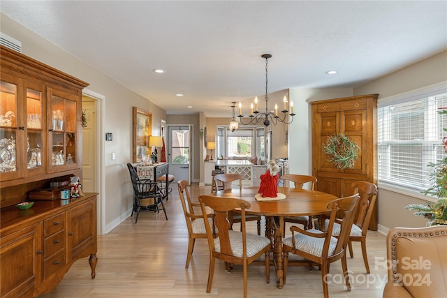 dining area with an inviting chandelier and light hardwood / wood-style flooring