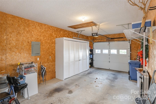 garage with electric panel and a garage door opener