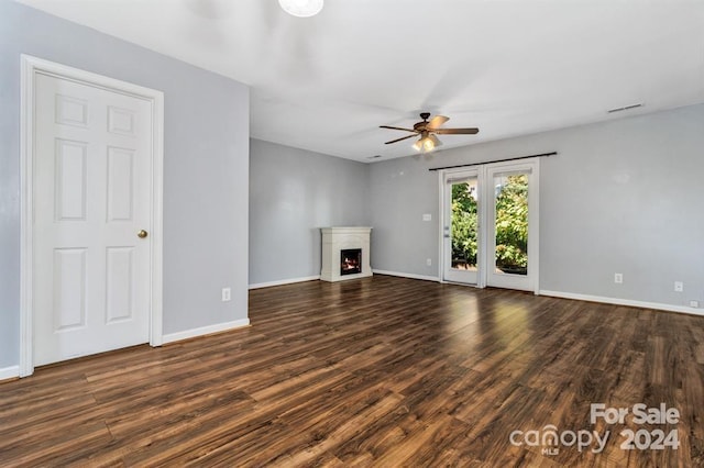 unfurnished living room featuring ceiling fan and dark hardwood / wood-style flooring