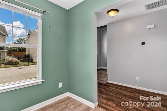 unfurnished room with dark hardwood / wood-style flooring