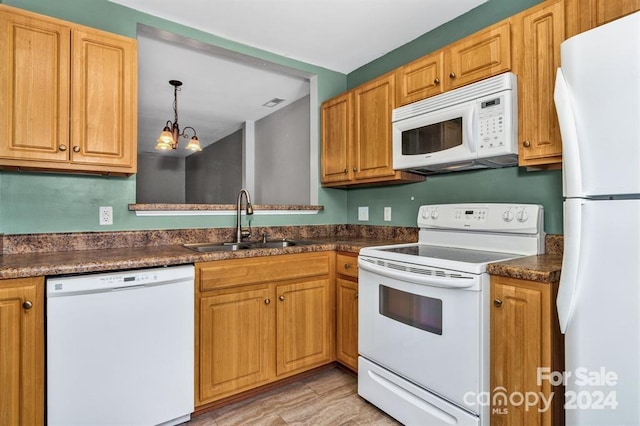 kitchen featuring decorative light fixtures, white appliances, sink, and an inviting chandelier