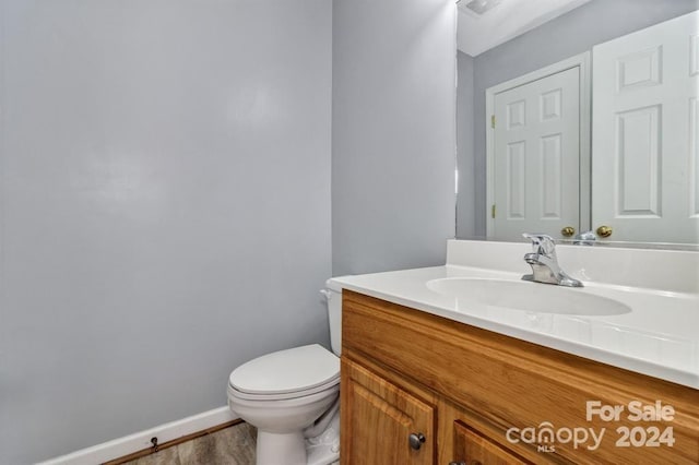 bathroom featuring hardwood / wood-style flooring, vanity, and toilet