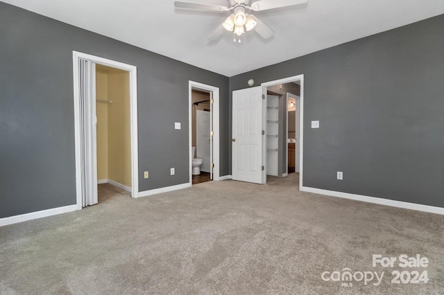 unfurnished bedroom featuring a walk in closet, ceiling fan, connected bathroom, carpet floors, and a closet