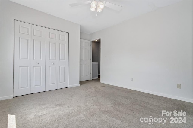 unfurnished bedroom featuring light carpet, a closet, and ceiling fan