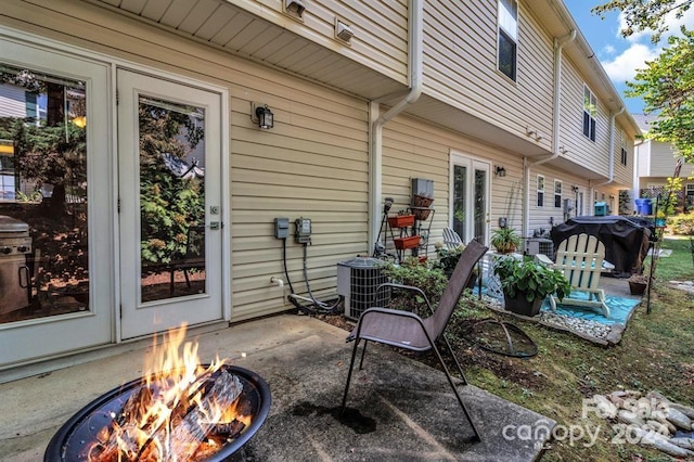 view of patio / terrace with an outdoor fire pit and cooling unit