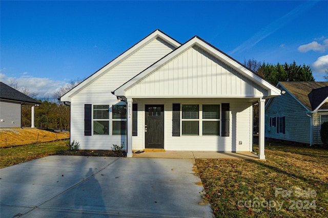 bungalow-style home with a front lawn and covered porch