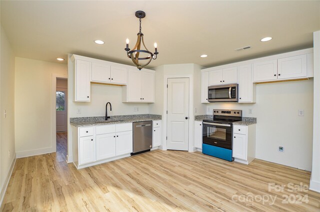 kitchen featuring white cabinetry, stainless steel appliances, and light hardwood / wood-style flooring