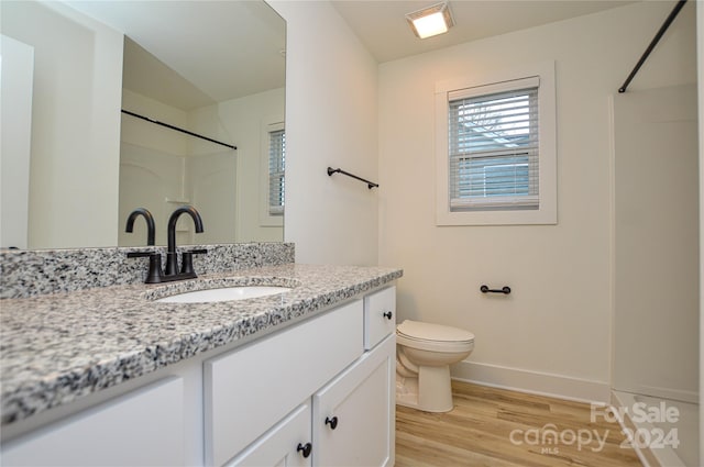 bathroom featuring hardwood / wood-style floors, vanity, and toilet