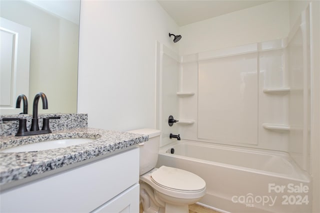 full bathroom featuring washtub / shower combination, vanity, and toilet