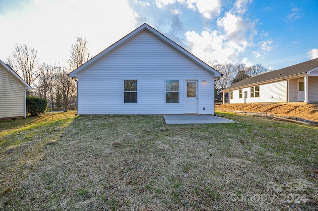 rear view of property with a lawn and a patio