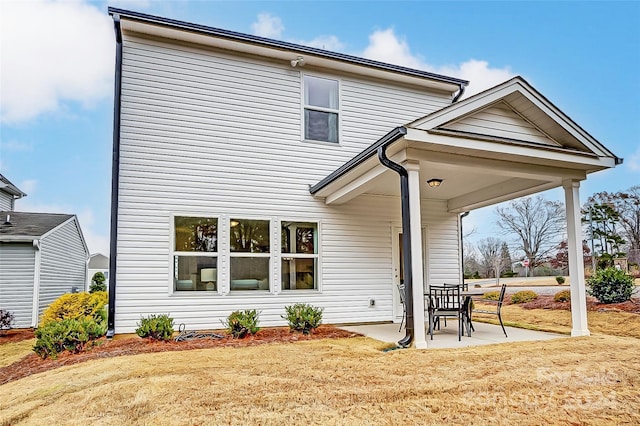 rear view of house featuring a patio area and a lawn