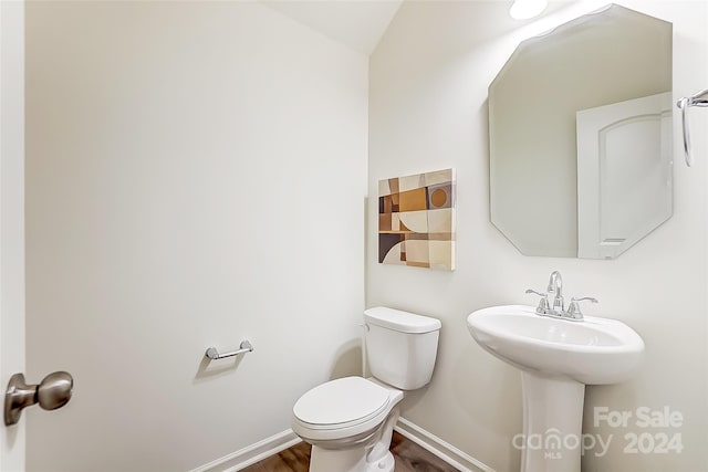 bathroom with wood-type flooring, toilet, and lofted ceiling