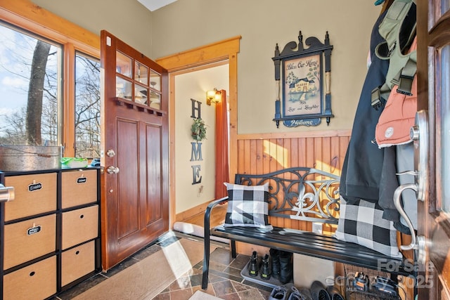 foyer entrance featuring dark tile patterned flooring and wooden walls