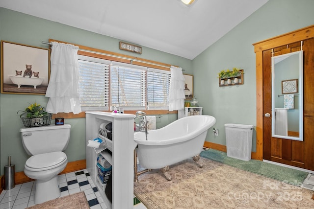 bathroom featuring lofted ceiling, toilet, and a bathing tub