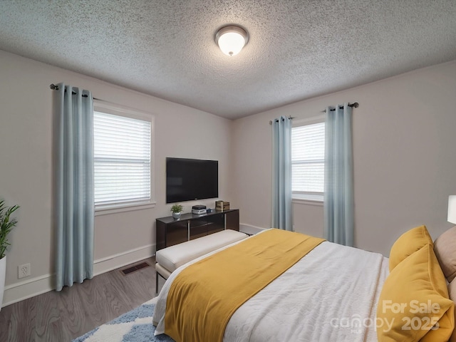 bedroom with hardwood / wood-style flooring and a textured ceiling