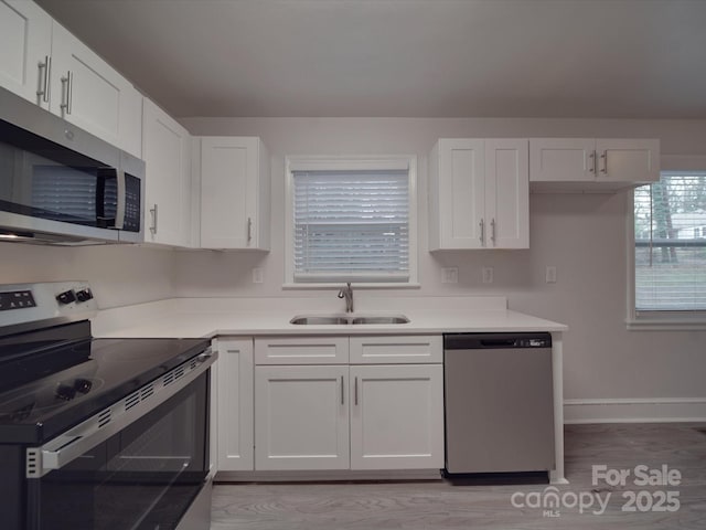 kitchen featuring white cabinetry, appliances with stainless steel finishes, and sink