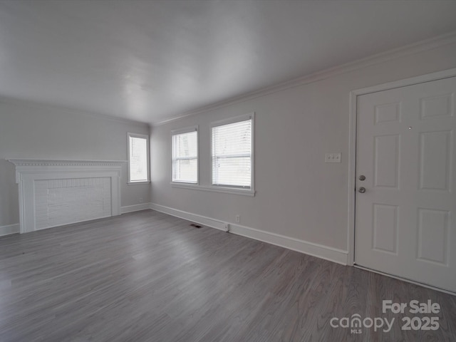 unfurnished living room featuring crown molding and dark hardwood / wood-style floors