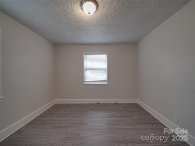 unfurnished room with hardwood / wood-style floors and a textured ceiling