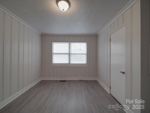 spare room with hardwood / wood-style floors and ornamental molding