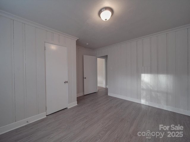 unfurnished bedroom with crown molding and hardwood / wood-style floors