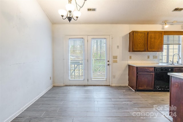 kitchen with backsplash, a textured ceiling, sink, a notable chandelier, and black dishwasher