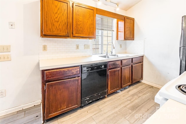 kitchen with backsplash, sink, black dishwasher, and light hardwood / wood-style flooring