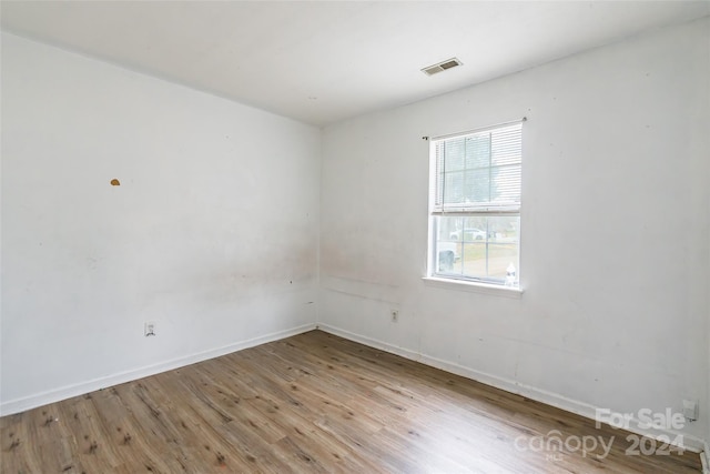 unfurnished room with hardwood / wood-style flooring